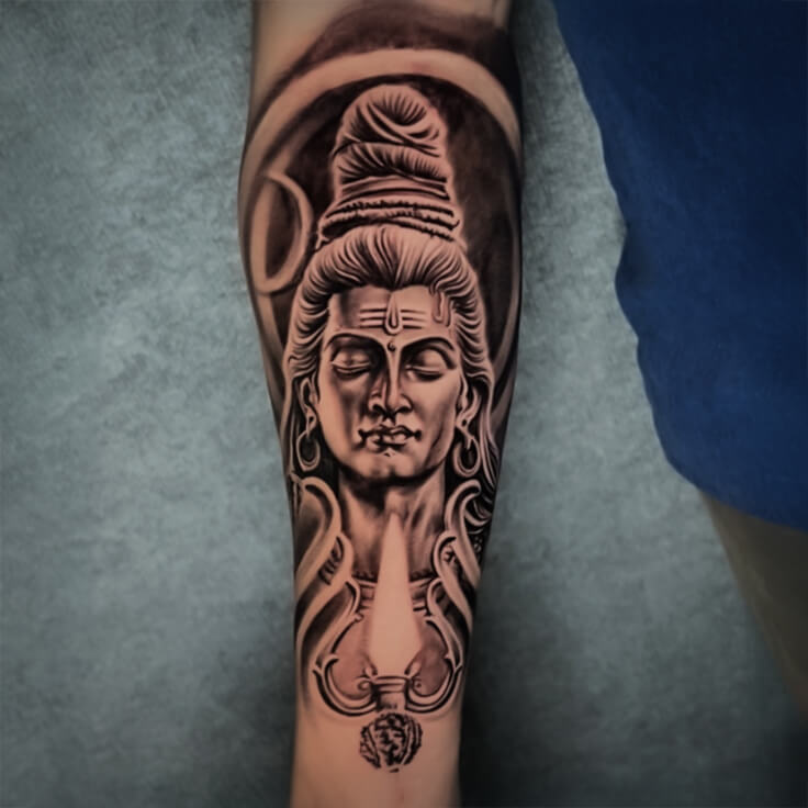 This forearm tattoo by Soumen Dutta captures the meditative essence of Adiyogi Shiva in exquisite black and grey realism.