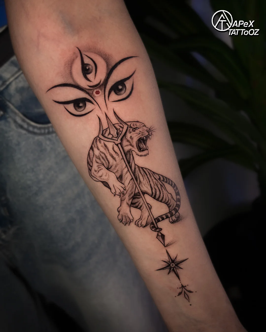 Durga-inspired forearm tattoo with goddess eyes, tiger and trishul at Apex Tattooz Delhi