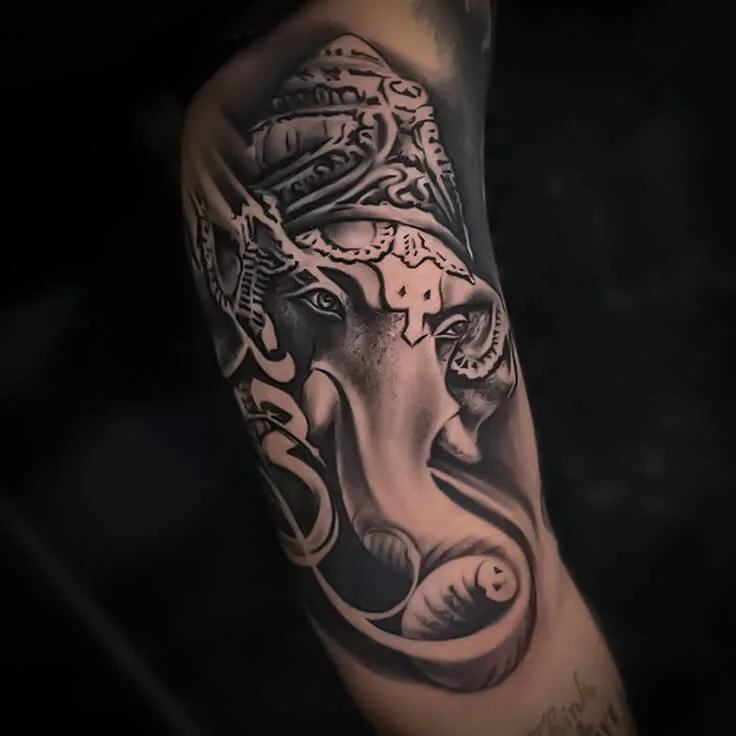 Black-and-grey Ganesha forearm tattoo with detailed ornamental shading by Apex Tattooz
