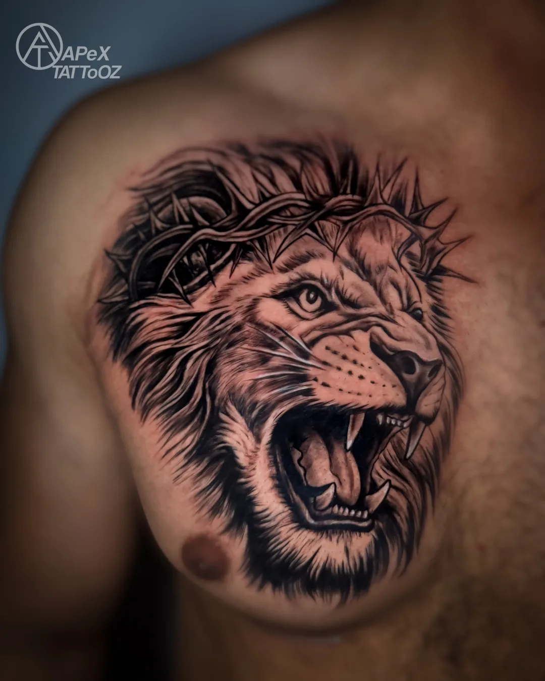 Roaring lion black-and-grey chest tattoo by Apex Tattooz Delhi