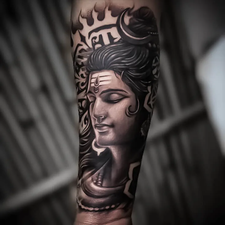 Serene black-and-grey Shiva forearm tattoo with detailed hair and adornments by Apex Tattooz