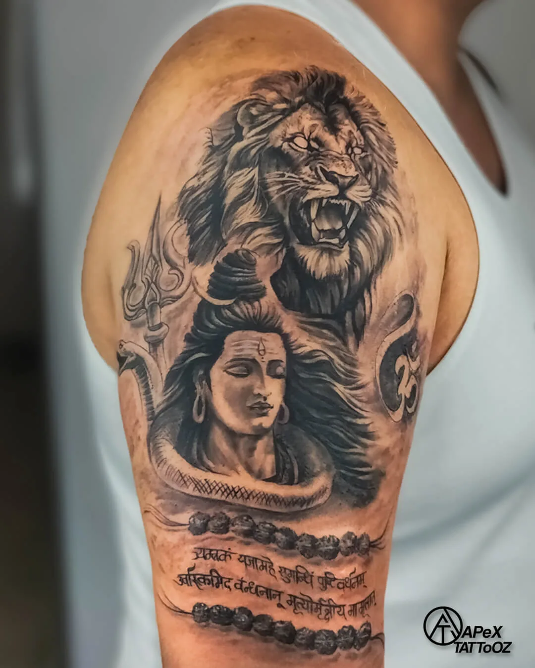 Shiva and tiger black-and-grey upper-arm tattoo by Apex Tattooz
