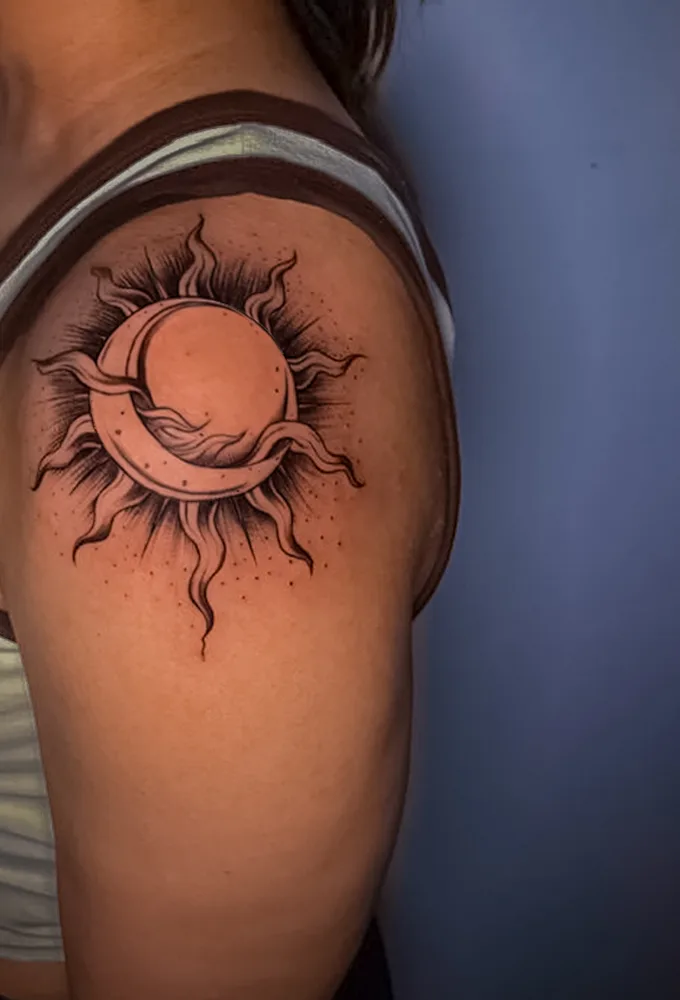 Sun and crescent moon fine-line tattoo on the upper arm by Apex Tattooz Delhi
