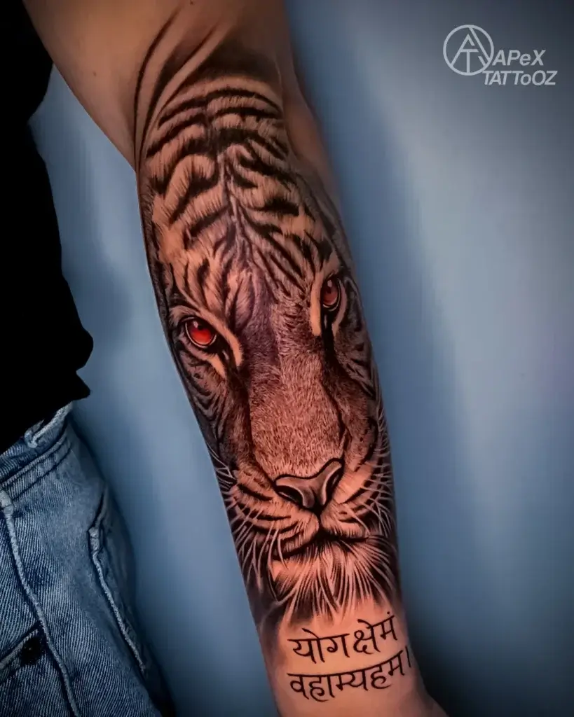 Realistic tiger face and Devanagari lettering tattoo on the forearm by Apex Tattooz Delhi