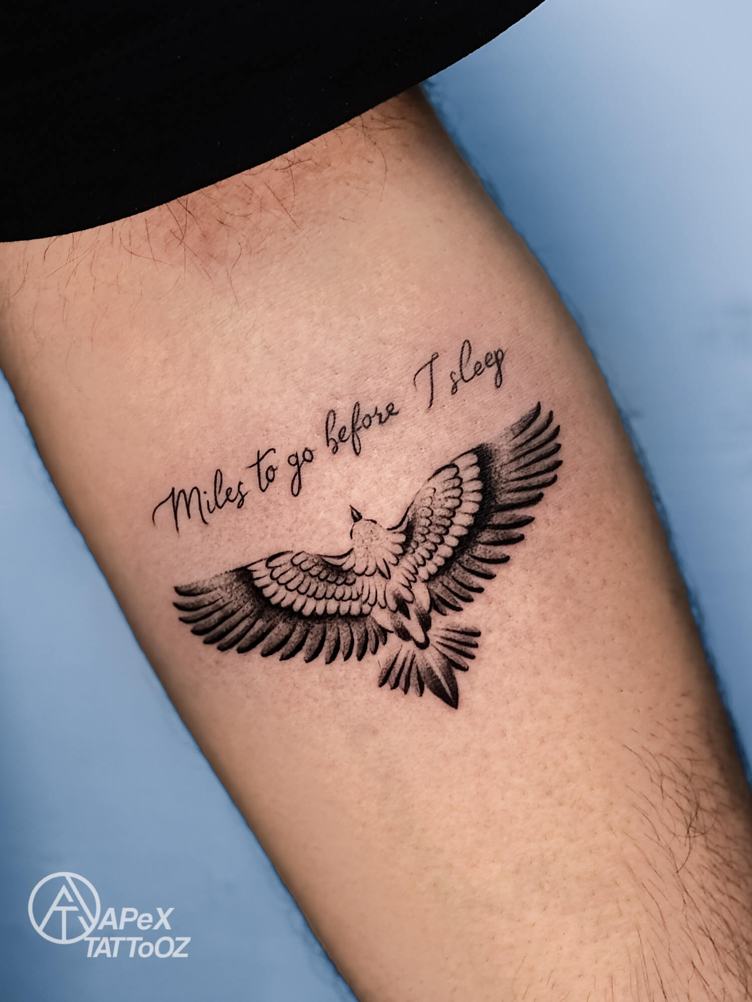 Spread-wing eagle tattoo beneath cursive lettering reading Miles to go before I sleep
