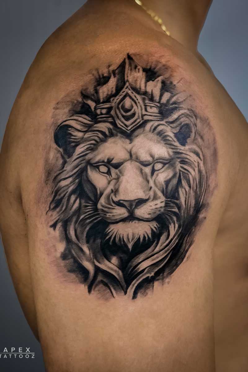 Black and grey lion tattoo symbolizing strength, royalty, custom design