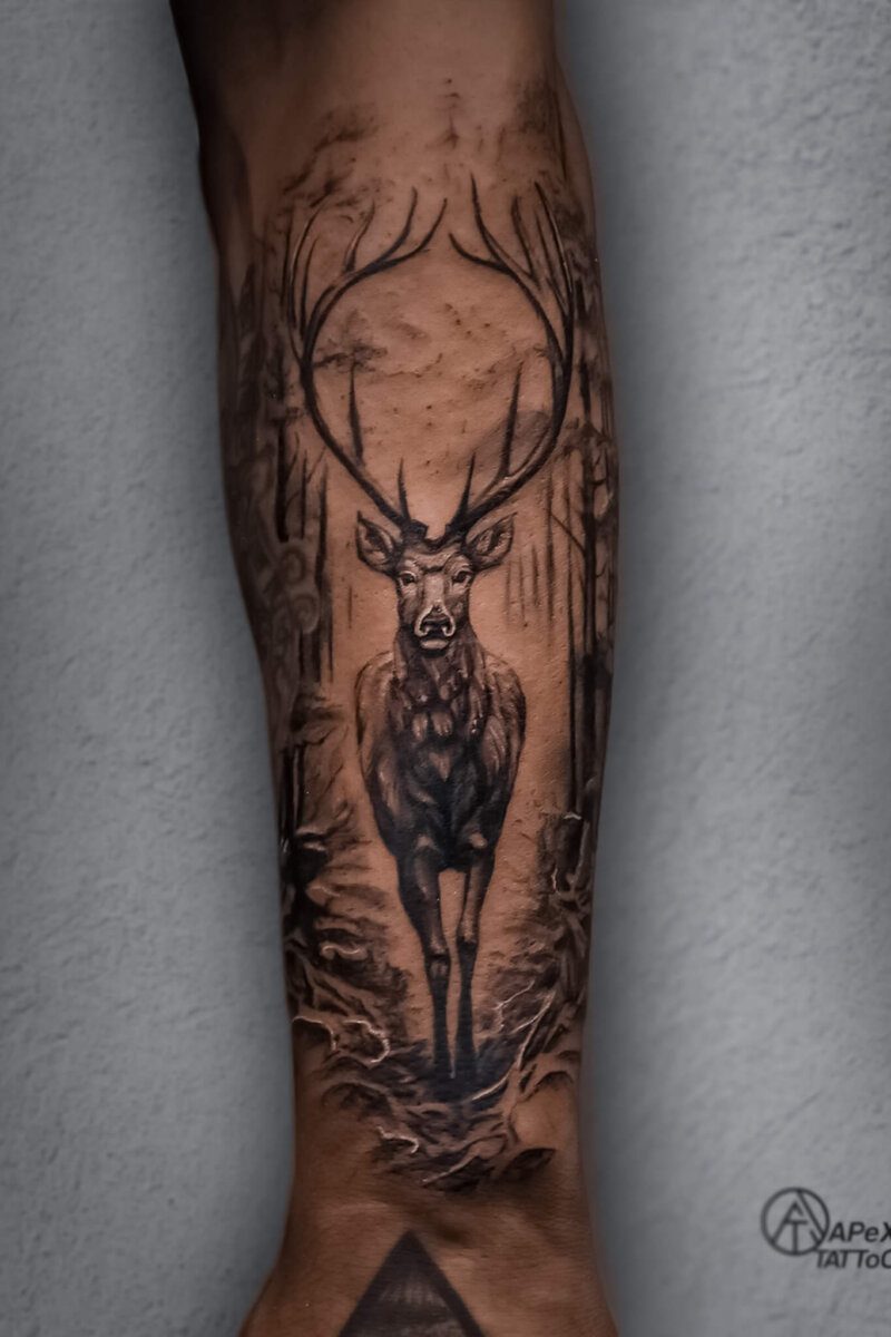 Realistic deer tattoo in forest scene on forearm – Apex Tattooz Delhi NCR