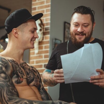 tattoo-artist-working-with-his-client-art-studio_118628-813 tattoo-artist-working-with-his-client-art-studio_118628-813